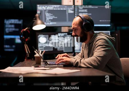 Software engineer typing code and creating algorithm for it startup company, writing html script on multiple monitors. App developer working with temrinal window and source code. Stock Photo