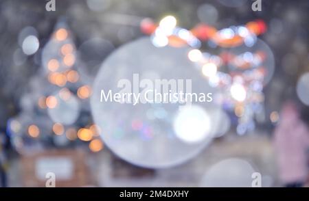 Beautiful Christmas trees decorated with luminous garlands on the street during heavy snowfall. Blurred white snowflake spot in the center. Blurred background. New Year Christmas holidays celebration Stock Photo
