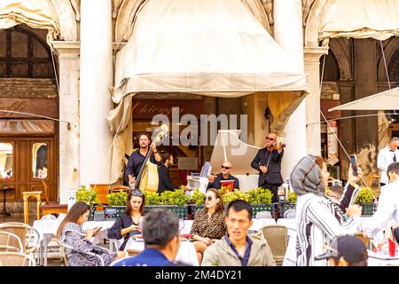 Live music in Gran Caffe Chioggia in San Marco square in Venice, Italy. Musicians in the cafe on San Marco. Tourists have coffee, aperol, make photos. Stock Photo