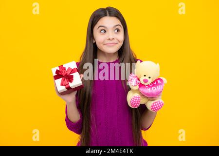 Cute teenager child girl congratulate with valentines day, giving romantic gift box. Present, greeting and gifting concept. Surprised emotions of Stock Photo