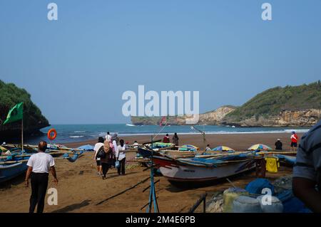 A beautiful ocean beach in Indonesia with a blue sky in the background is crowded with tourists during the day Stock Photo