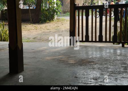 House terrace with pillars and wooden fence in Yogyakarta, Indonesian. Sunlight shadow. Background crowd of people. Stock Photo