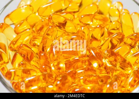 Omega-3 Fish oil capsules in a glass bowl on white marble background healthy eating, Food medical supplement, vitamins D Stock Photo