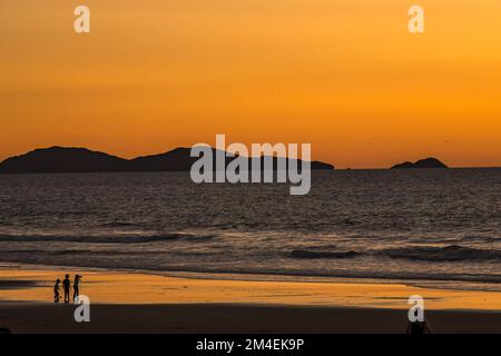 Coronado Islands off Baja Mexico at sunset. People play at the beach in Southern California.  Stock Photo