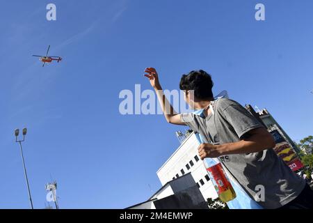 (221221) -- BUENOS AIRES, Dec. 21, 2022 (Xinhua) -- A fan waves to the helicopter carrying members of Team Argentina after the team winning the Final of the 2022 FIFA World Cup in Buenos Aires, capital of Argentina, Dec. 20, 2022. (TELAM/Handout via Xinhua) Stock Photo