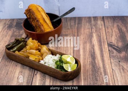 torta ahogada consome y birria, dish with onion, sweet onion and chile, wooden plates beef soap Stock Photo