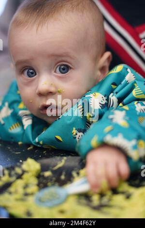 Baby making a mess while eating Stock Photo