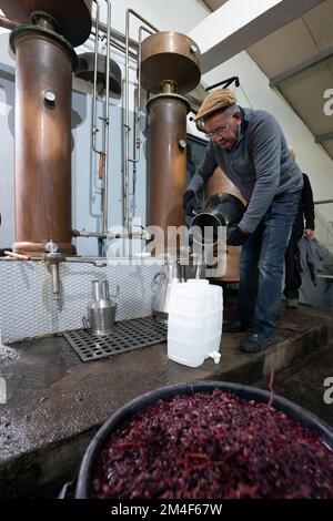 Man making traditional portuguese brandy Aguardente from grape pomace in a copper still at an old fashion distillery in Oleiros, Portugal, Europe Stock Photo