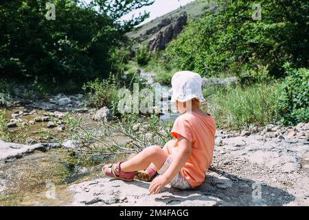 Little girl alone in nature. Shot from the back without a face Stock Photo