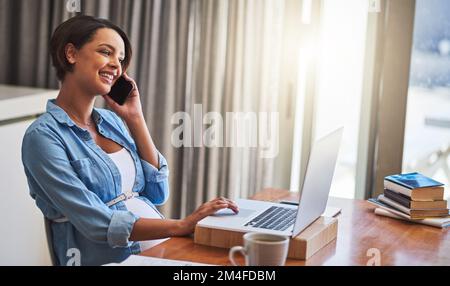 On maternity leave...or not quite. a pregnant young woman using a laptop and mobile phone while working from home. Stock Photo