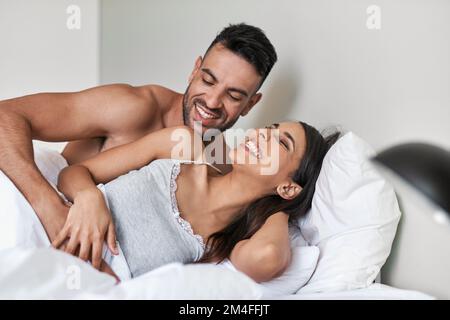 The most comfortable bed is one that youre in. an affectionate young married couple in bed at home. Stock Photo