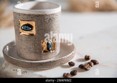 luxury hand made ceramic coffee cup with coffee beans Stock Photo