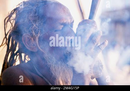 Sadhu, holy man, smoking marihuana during Kumbha Mela.   Haridwar Stock Photo