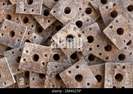 Square base plates of stacked old construction props in close-up Stock Photo