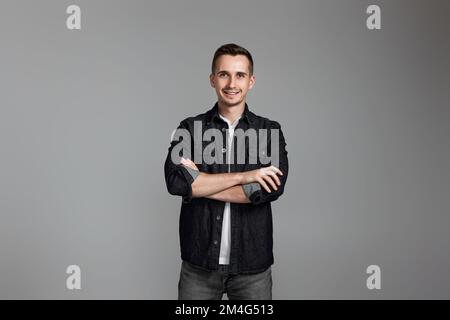 smiling young guy posing with crossed arms Stock Photo