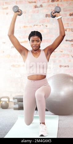 Gym, dumbbells or strong black woman training, exercise or workout for  powerful arms or muscles. Wellness, health or African girl lifting weights  or exercising shoulders with energy in fitness studio by YuriArcurs