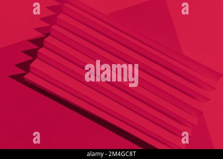 Viva Magenta color of the year 2023. Abstract crimson red color  paper texture. Folded paper with harsh sun shadows, geometric shapes and lines. Stock Photo