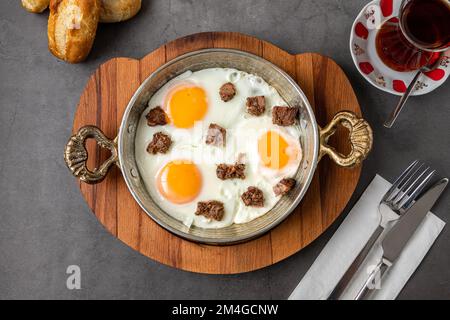 Turkish scrambled eggs Turkish name Kavurmali Yumurta with roasted meat in copper pan Stock Photo