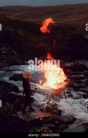 Scotland, UK. 25th October 2021. A person posing as Boris Johnson and another with an oil tank for a head light fire and dump fake toxic waste in the Fairy Pools in a theatrical action staged by members of Ocean Rebellion a sister group to Extinction Rebellion ahead of the COP26 conference in Glasgow. Stock Photo