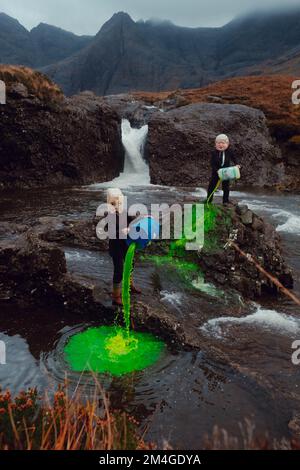 Scotland, UK. 25th October 2021. A person posing as Boris Johnson and another with an oil tank for a head light fire and dump fake toxic waste in the Fairy Pools in a theatrical action staged by members of Ocean Rebellion a sister group to Extinction Rebellion ahead of the COP26 conference in Glasgow. Stock Photo