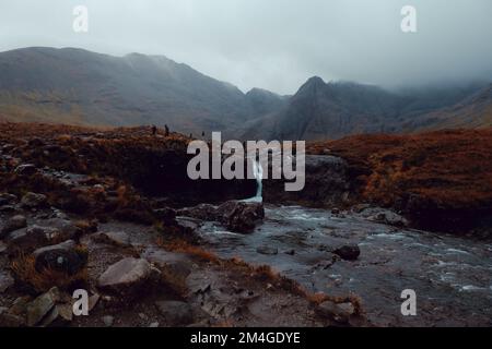 Scotland, UK. 25th October 2021. A person posing as Boris Johnson and another with an oil tank for a head light fire and dump fake toxic waste in the Fairy Pools in a theatrical action staged by members of Ocean Rebellion a sister group to Extinction Rebellion ahead of the COP26 conference in Glasgow. Stock Photo