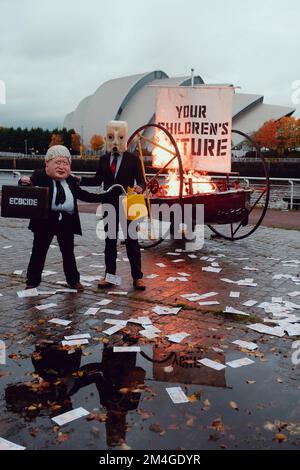Scotland, UK. 27th October 2021. A person posing as Boris Johnson and another with an oil tank for a head set a boat on fire with in front of the UN COP26 conference centre in Glasgow. This theatrical action is staged by members of Ocean Rebellion a sister group to Extinction Rebellion. Stock Photo