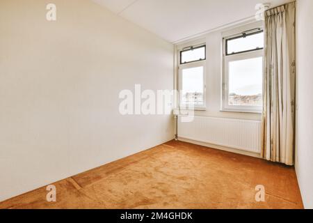 a room with two windows and a rug on the floor in front of the window looking out onto the street Stock Photo