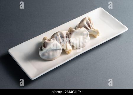 traditional georgian khinkali on white plate on black background Stock Photo