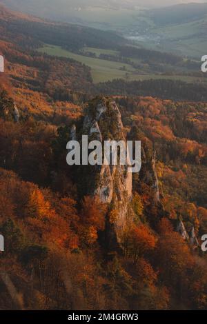 Sunset over autumn colourful forests surrounding Sulovske rocks in Slovakia, eastern Europe. Red-orange forest vegetation. Stock Photo