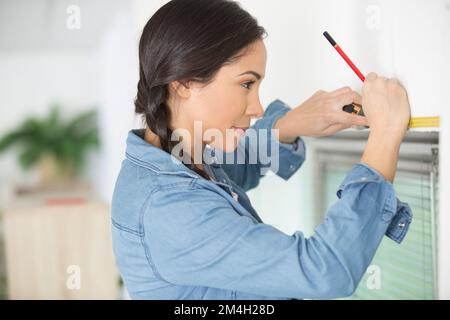 woman is measuring window frame Stock Photo