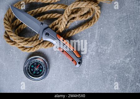 Tactical folding knife for survival, rope and compass, survival kit in  difficult conditions. Stock Photo