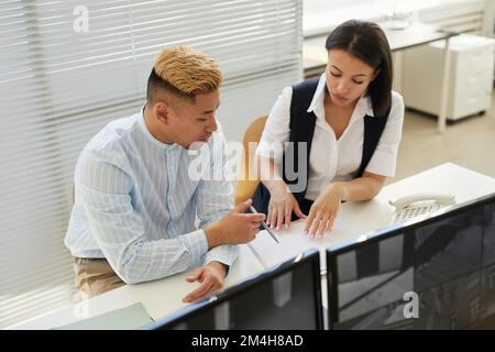 High angle portrait of two people pointing at document while working in data security office Stock Photo