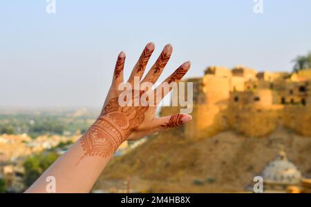 Henna tattoo on woman hands with old town background in sunny day. Stock Photo