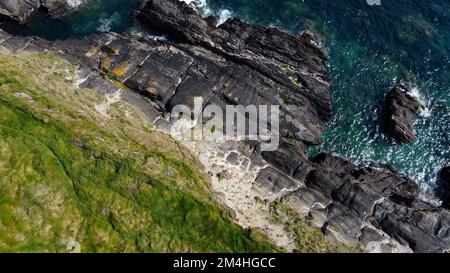 Dense thickets of grass on the shore. Grass-covered rocks on the Atlantic Ocean coast. Nature of Ireland, top view. Aerial photo. View from above. Stock Photo