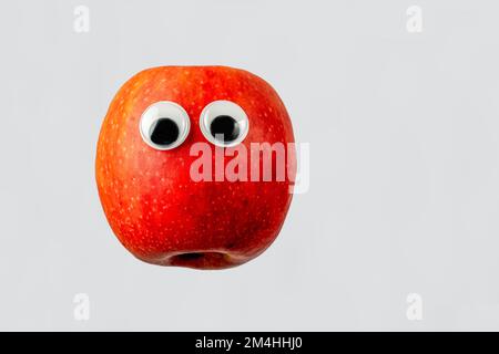 pink lady sweet dessert apple googly eyed isolated on a white background Stock Photo