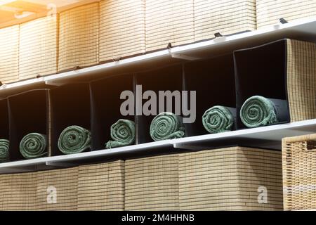 Green towels in square wicker baskets on store shelves Stock Photo