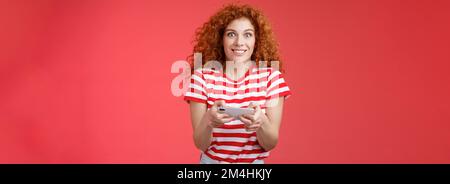 Excited happy cute redhead curly-haired girlfriend eager start learn how play boyfriend game look amused cheerful camera smiling joyful hold Stock Photo