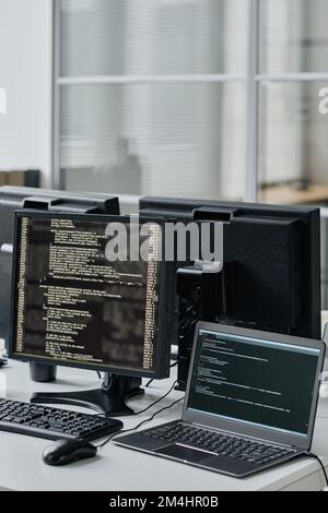 Close-up of workplace of developers with computers and laptop on table for online work Stock Photo