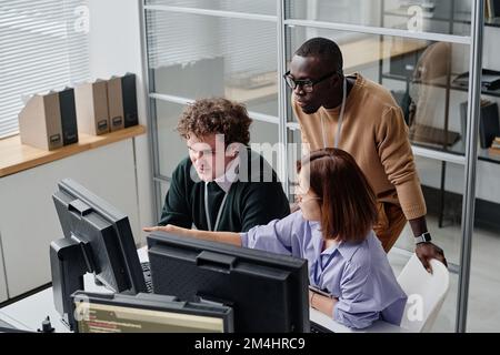 High angle view of team of programmers developing security program on computers during their work in office Stock Photo