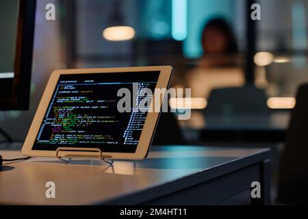 Close-up of digital tablet with security program codes on touch screen standing on table of developer Stock Photo