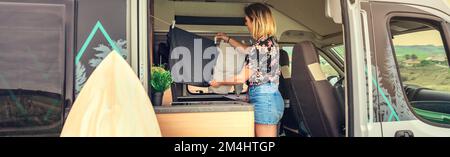 Woman hanging out the laundry inside her camper van Stock Photo