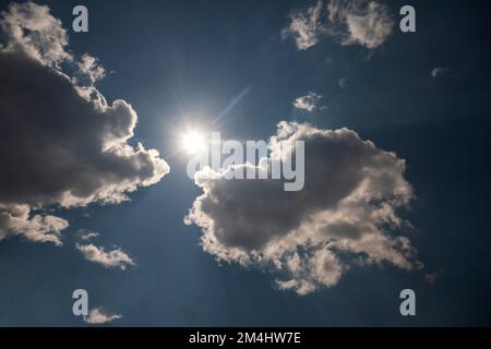Sunny background, blue sky with white clouds and sun Stock Photo