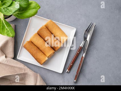 Homemade roll crepes with meat on a plate on a blue  background with fresh herb. Healthy food concept. Top view and copy space. Stock Photo