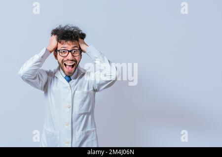 A mad scientist pulling his hair out on isolated background. Mad scientist grabbing his hair with a mad face isolated. A doctor with a crazy face Stock Photo