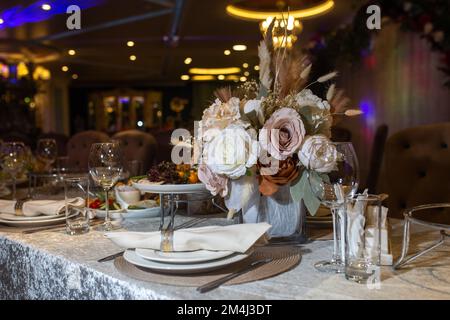 White napkins, beautifully folded on plates in a restaurant. Restaurant interior Stock Photo