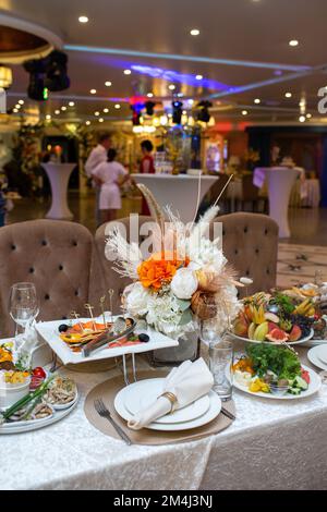 White napkins, beautifully folded on plates in a restaurant. Restaurant interior Stock Photo