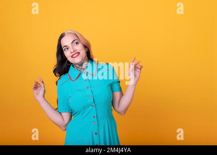 Beautiful woman posing to the camera over yellow background. Studio Shot Stock Photo