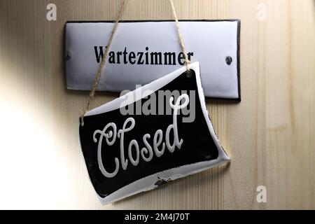 enamel sign on the door to the (closed) waiting room of a German doctor's office Stock Photo