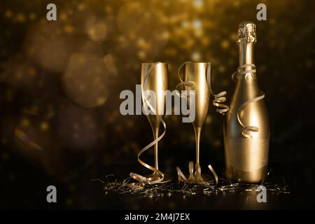 golden champagne bottle and two glasses with ribbons on black bokeh background. new year and anniversary celebration. copy space Stock Photo