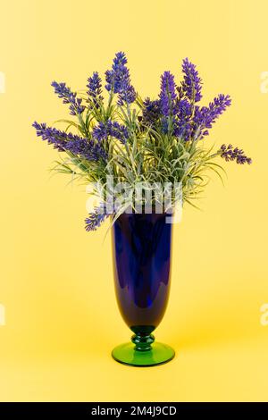 Artificial lavender in vase on yellow background Stock Photo